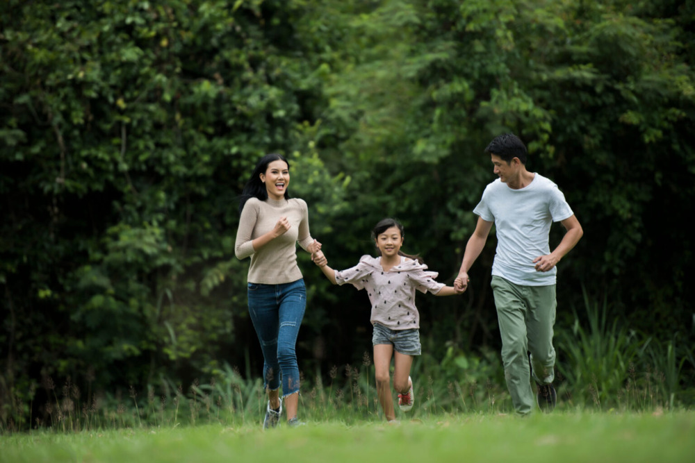 Malaysian family running together outdoors