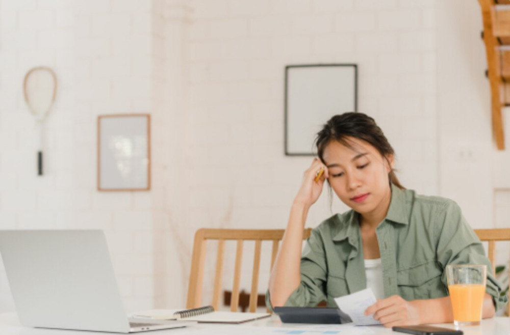 Woman reviewing bills under financial pressure